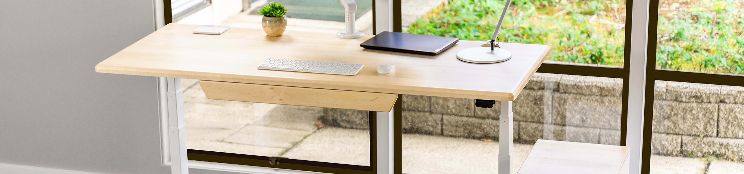 Solid Wood Lander Standing Desk with optional Premium Drawer, shown in Natural Maple finish