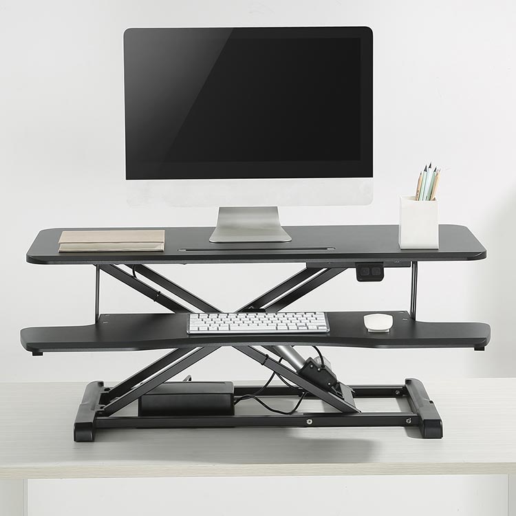 The Flexus E Electric Standing Desk Converter in use.